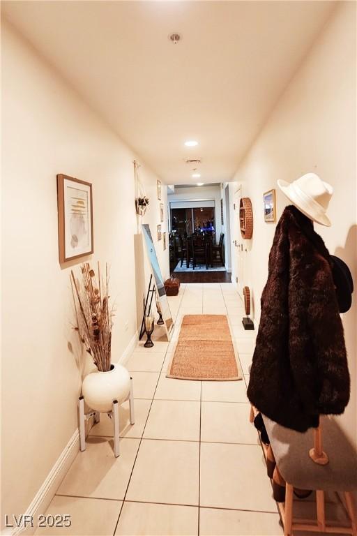 hall featuring tile patterned flooring and baseboards