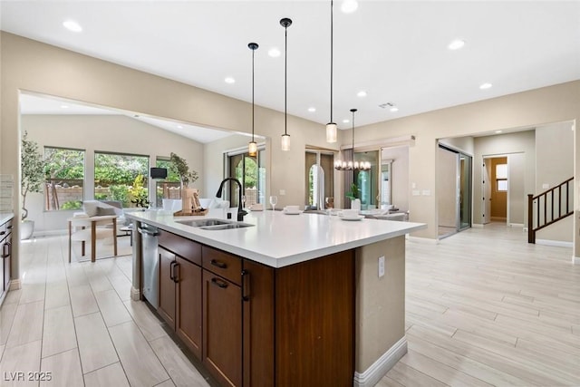 kitchen featuring recessed lighting, light countertops, open floor plan, a kitchen island with sink, and a sink