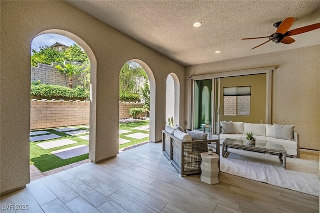 view of patio / terrace with outdoor lounge area, fence, and a ceiling fan