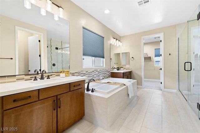 bathroom featuring visible vents, a sink, a shower stall, tile patterned flooring, and a bath