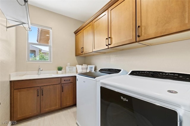 clothes washing area featuring a sink, cabinet space, and washer and dryer