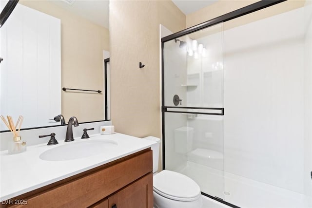 bathroom featuring a stall shower, vanity, and toilet