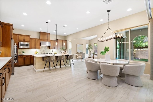 dining area featuring light wood finished floors, visible vents, and recessed lighting