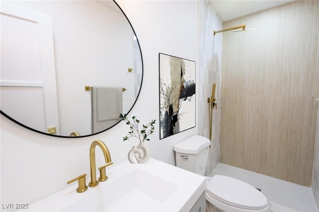 bathroom with toilet, vanity, and a tile shower