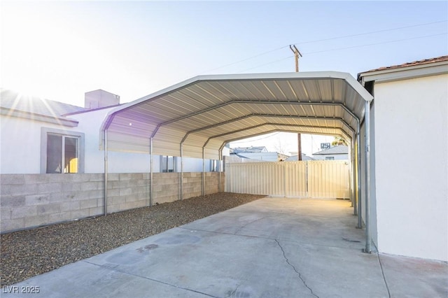 view of parking / parking lot featuring a detached carport and fence