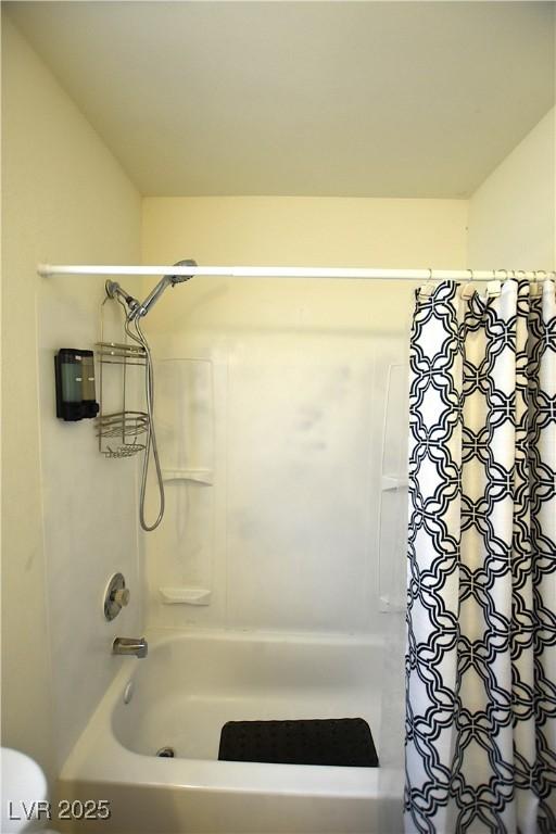 bathroom featuring shower / bath combo with shower curtain and toilet