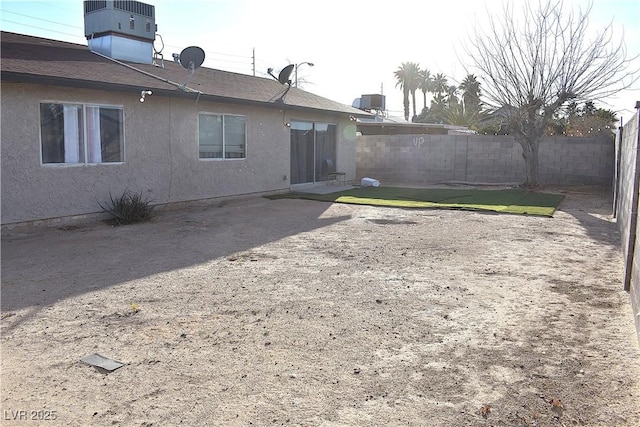 view of yard featuring central AC and fence