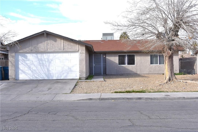 single story home featuring a garage, driveway, and stucco siding