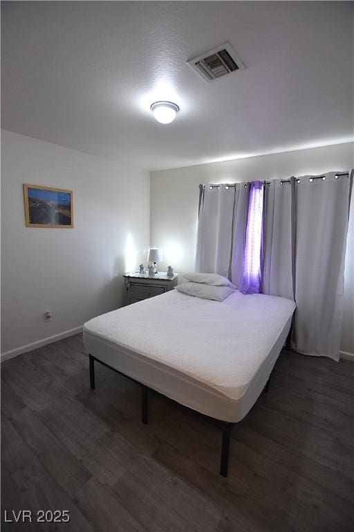 bedroom featuring dark wood-style floors, visible vents, and baseboards