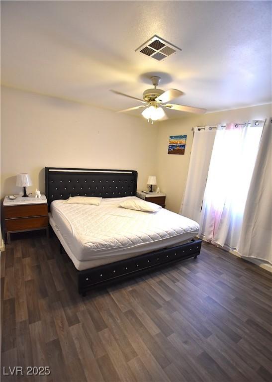 bedroom featuring visible vents, dark wood finished floors, and a ceiling fan