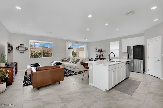 kitchen featuring a sink, visible vents, appliances with stainless steel finishes, and open floor plan