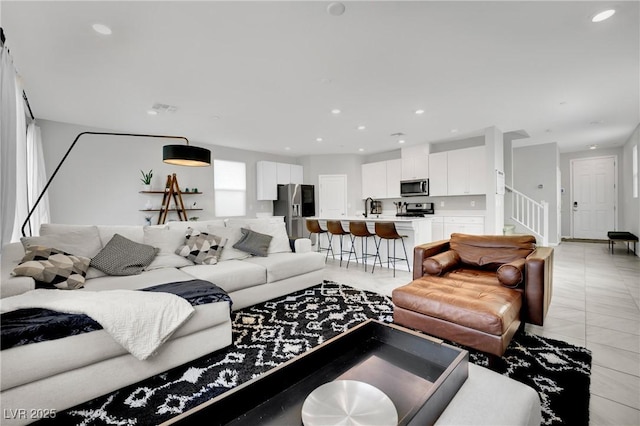 living area featuring stairs, recessed lighting, and visible vents