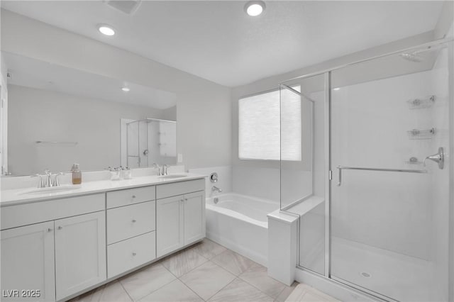 bathroom featuring a sink, a garden tub, a stall shower, and double vanity