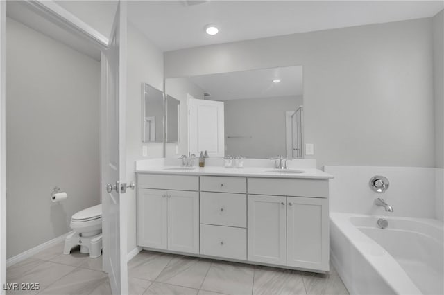 bathroom featuring double vanity, toilet, a garden tub, and a sink