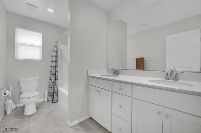 bathroom with a sink, baseboards, toilet, and double vanity