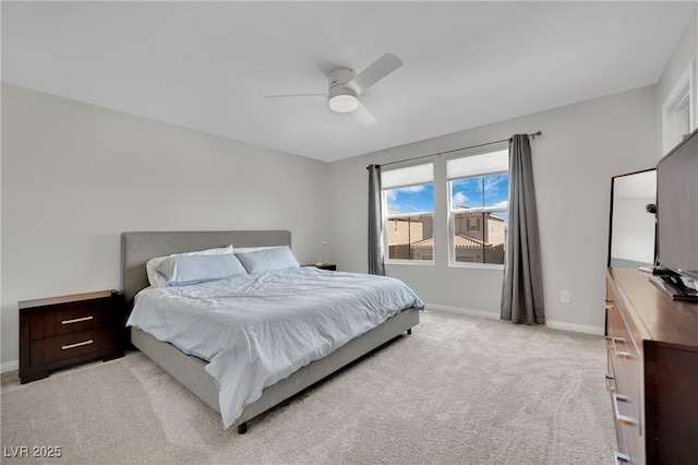 bedroom featuring baseboards, light colored carpet, and a ceiling fan