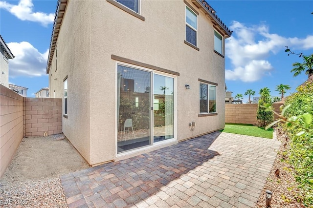 back of house featuring a patio area, stucco siding, and a fenced backyard