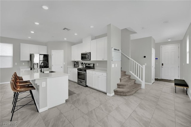 kitchen with visible vents, stainless steel appliances, light countertops, and a sink