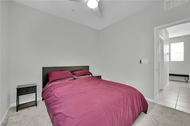 carpeted bedroom featuring a ceiling fan, tile patterned floors, baseboards, and visible vents