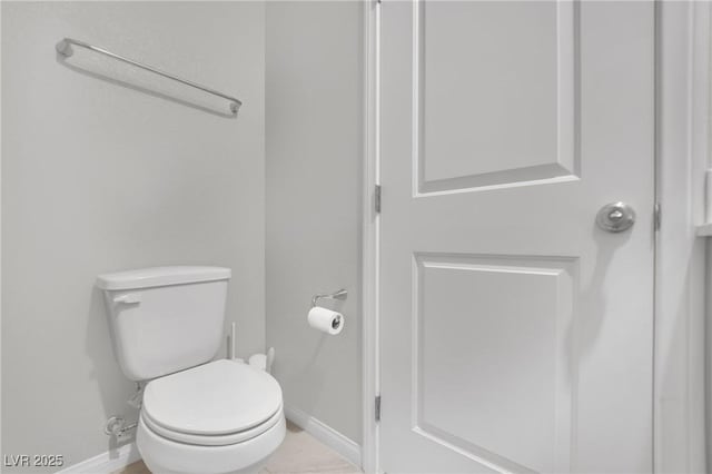 bathroom featuring toilet and baseboards