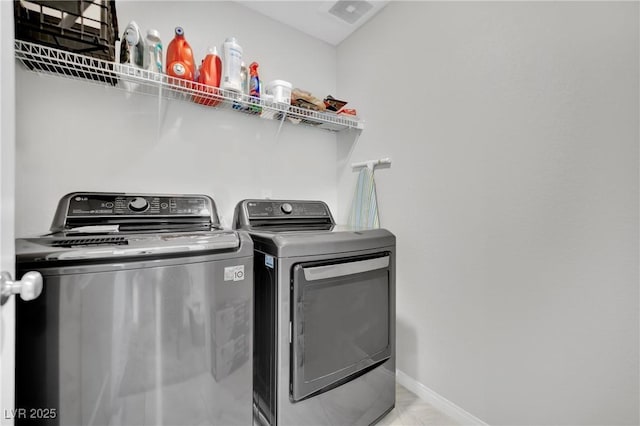 clothes washing area featuring washer and dryer, baseboards, and laundry area