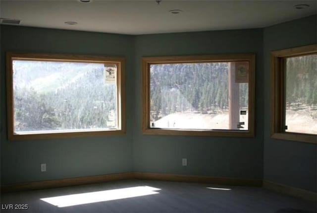 empty room featuring baseboards and visible vents