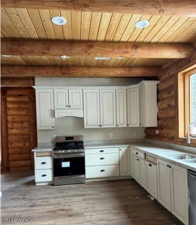 kitchen with a sink, stainless steel appliances, light wood finished floors, and light countertops