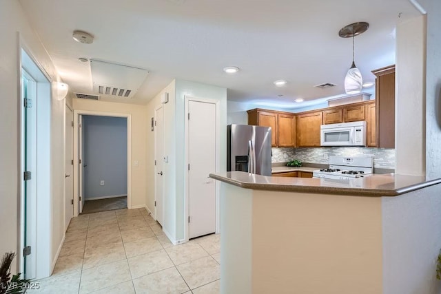 kitchen with tasteful backsplash, white appliances, visible vents, and brown cabinets