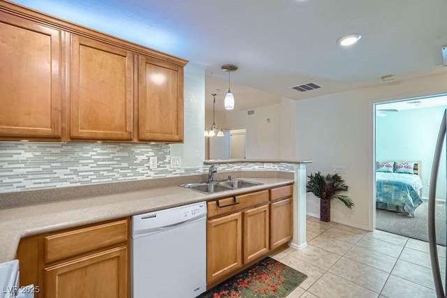 kitchen with decorative light fixtures, light tile patterned floors, tasteful backsplash, a sink, and dishwasher