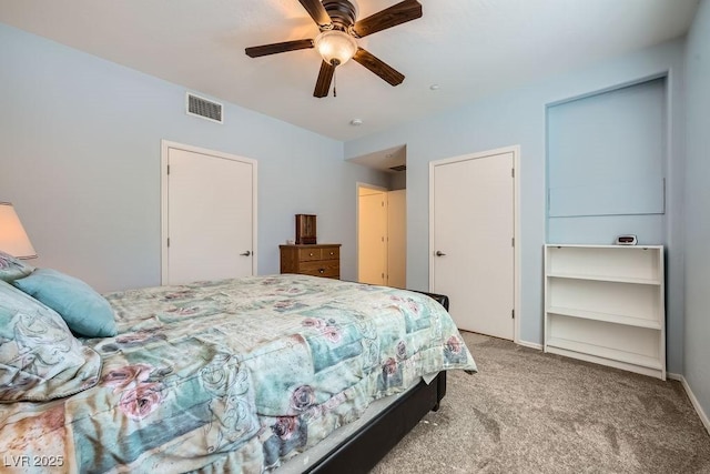 carpeted bedroom featuring ceiling fan, visible vents, and baseboards