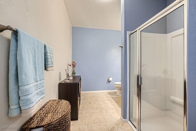 bathroom with baseboards, a stall shower, toilet, and tile patterned floors