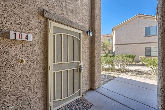 doorway to property featuring stucco siding