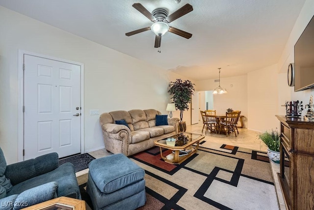 living room with ceiling fan with notable chandelier