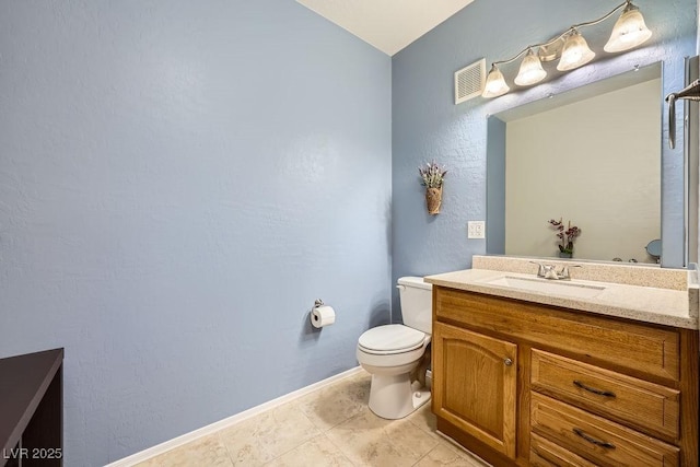 bathroom with visible vents, toilet, vanity, baseboards, and tile patterned floors