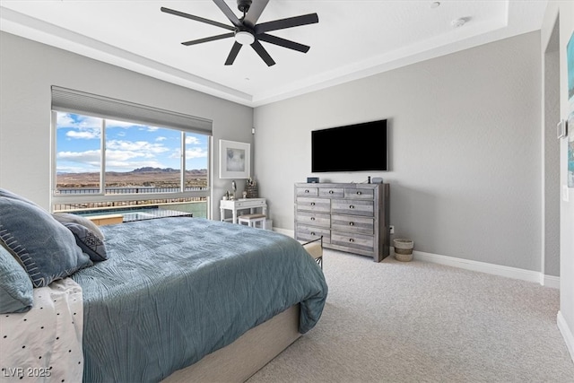 bedroom with a tray ceiling, baseboards, ceiling fan, and carpet flooring