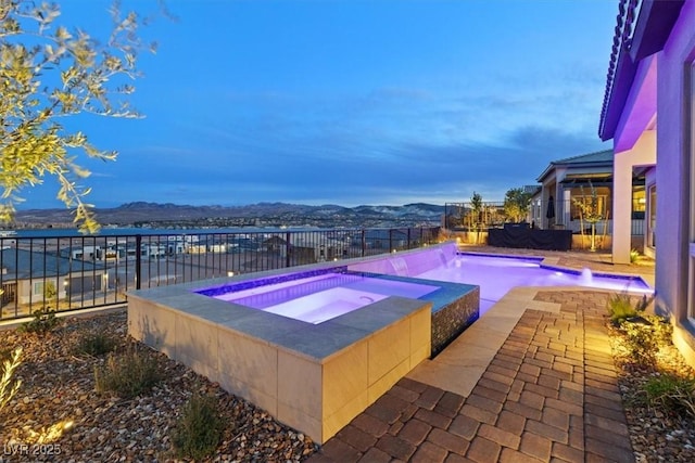 view of swimming pool featuring a fenced in pool, a fenced backyard, a patio, and an in ground hot tub