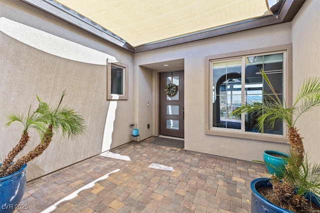 doorway to property with a patio and stucco siding