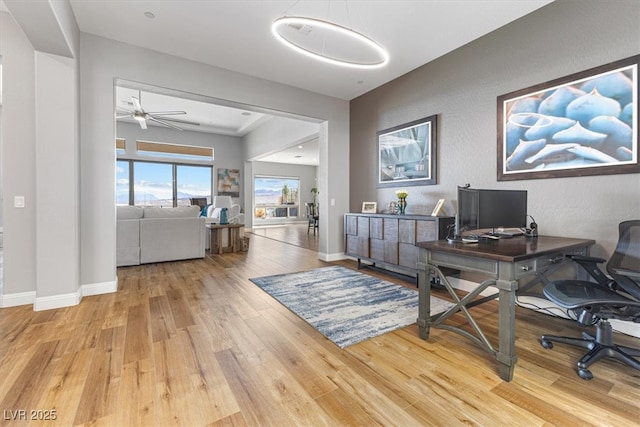 office area featuring light wood finished floors, ceiling fan, and baseboards