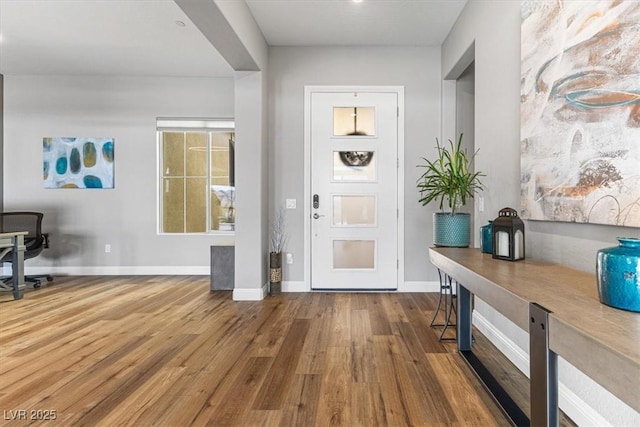 foyer entrance with baseboards and wood finished floors