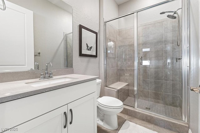 bathroom with toilet, tile patterned flooring, a shower stall, and vanity