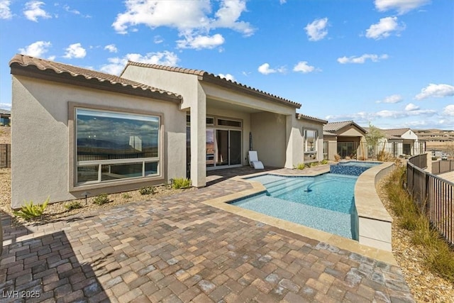 view of pool featuring a patio, fence, and a pool with connected hot tub