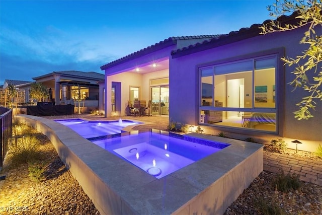 view of patio / terrace featuring outdoor dining space, an outdoor pool, and an in ground hot tub