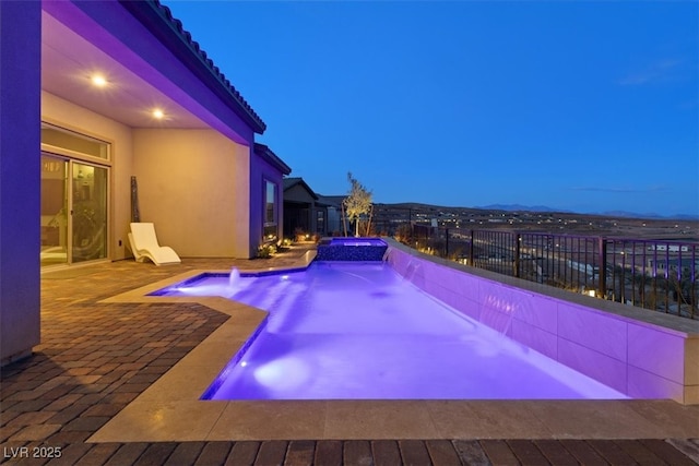 view of pool featuring a patio, a fenced backyard, and a pool with connected hot tub