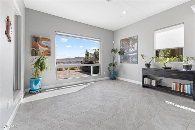 doorway featuring tile patterned floors and baseboards