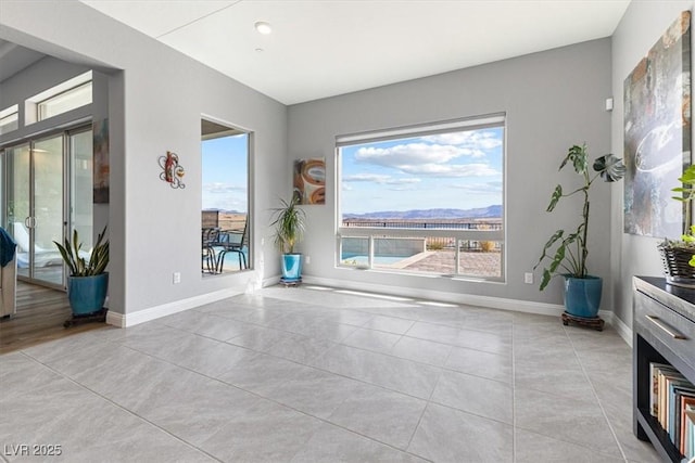 empty room with light tile patterned floors and baseboards