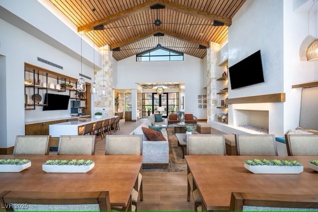 dining area featuring wooden ceiling, beam ceiling, high vaulted ceiling, and wood finished floors