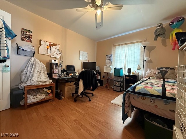 bedroom featuring a ceiling fan, lofted ceiling, and wood finished floors