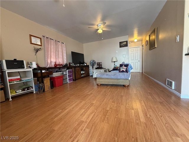 bedroom with a ceiling fan, baseboards, visible vents, and wood finished floors