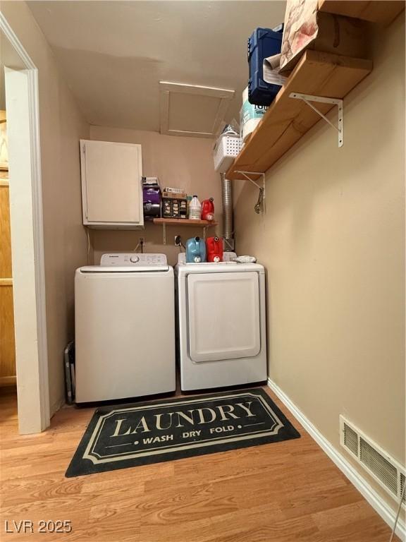 laundry room featuring laundry area, visible vents, washer and dryer, light wood finished floors, and attic access