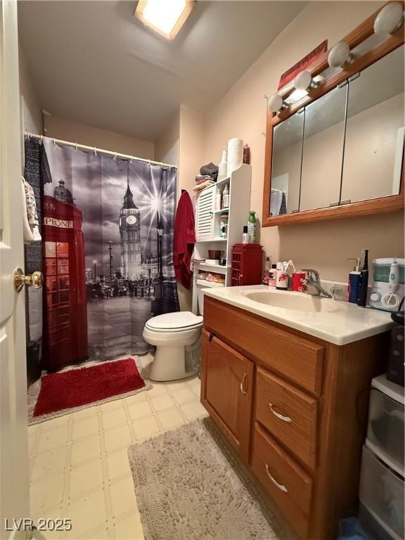 bathroom with toilet, vanity, and tile patterned floors